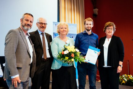 fünf Personen stehen auf einer Bühne, Übergabe des Landessiegels
