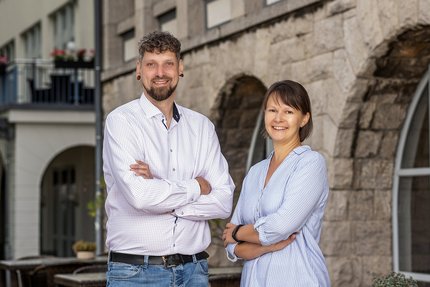 Ein Mann und eine Frau stehen vor einem Gebäude: Direktion und Marketing des Weinberghotel Edelacker GmbH