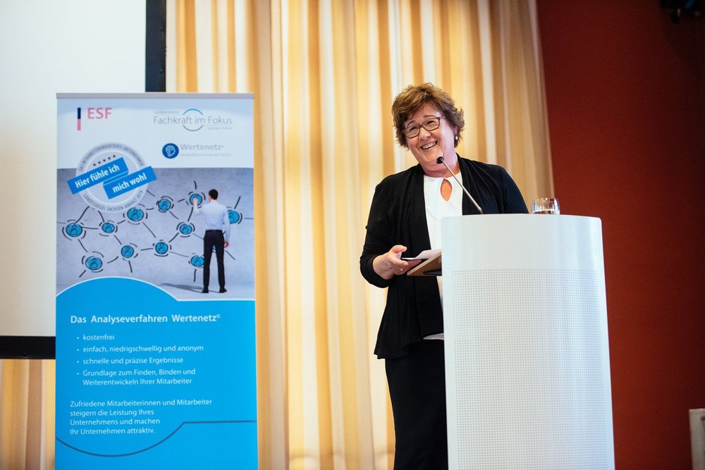 Ministerin Grimm-Benne steht auf der Bühne und hält ein Grußwort