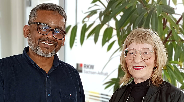 Ein Mann und eine Frau stehen nebeneinander und blicken freundlich lächelnd in die Kamera