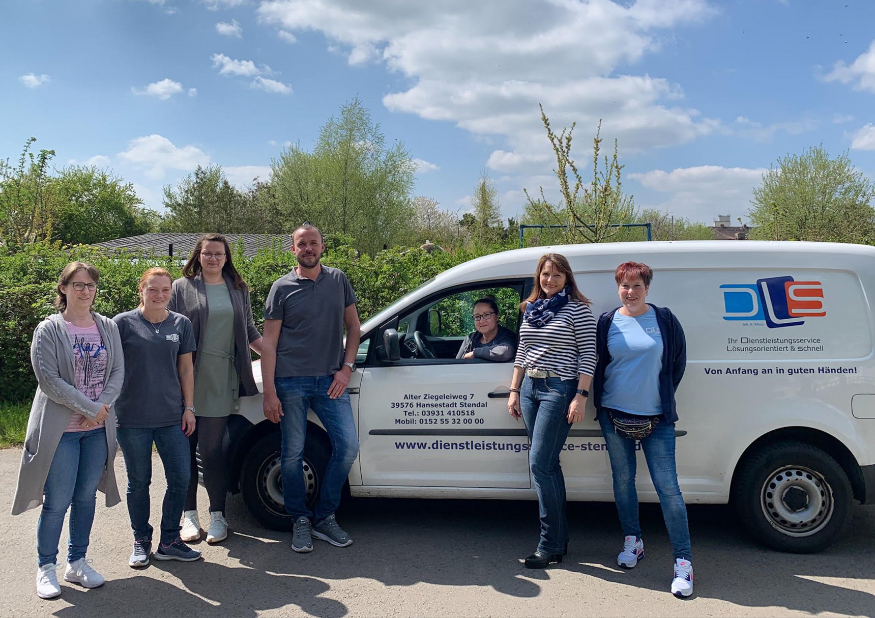 sechs Mitarbeiter des Dienstleistungsservice Elke Krause stehen vor ihrem Dienstauto