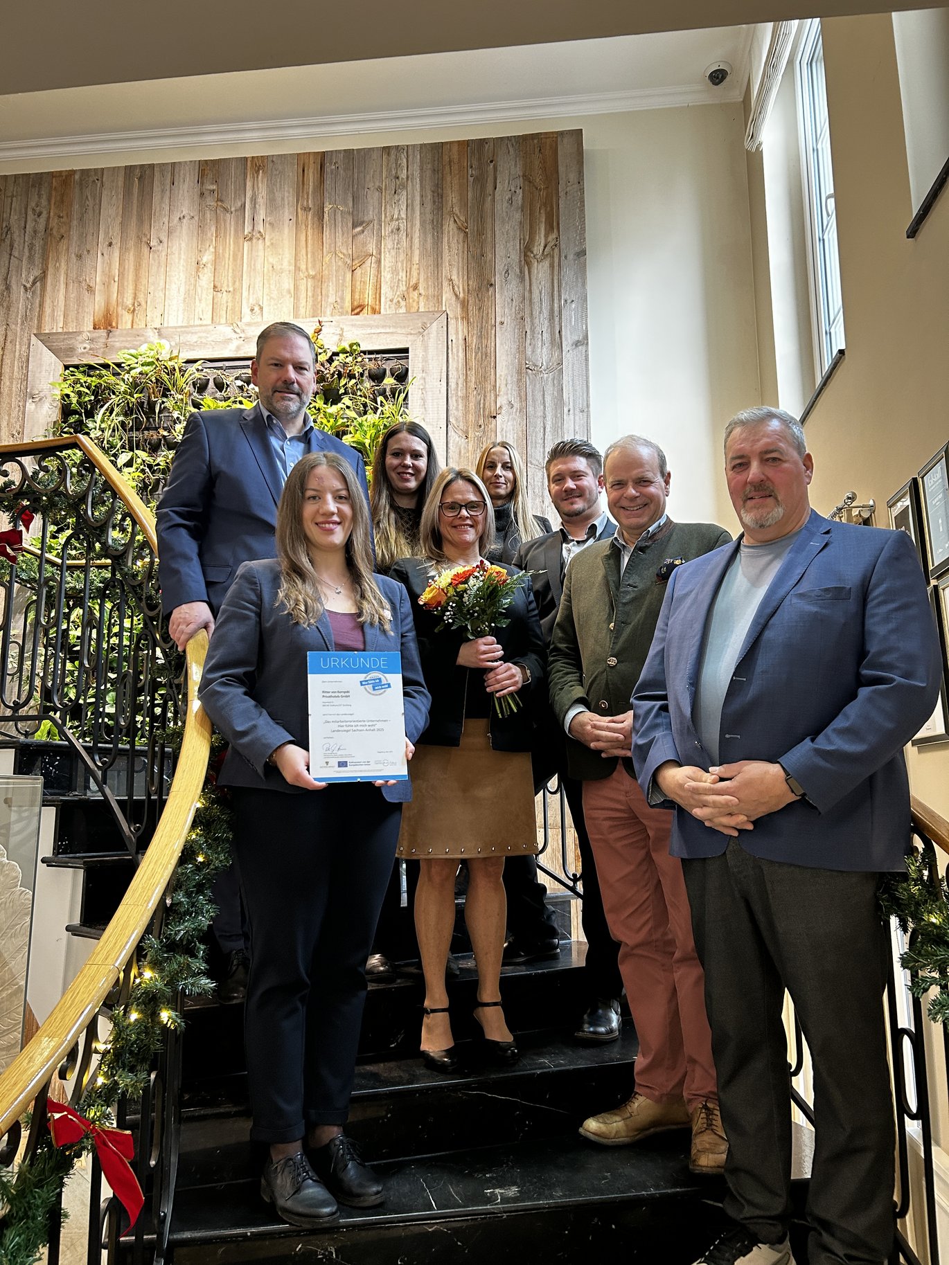 acht Menschen stehen auf einer Treppe im Hotel Schindelbruch