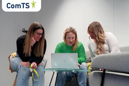 Drei Frauen sitzen um einen PC herum und schauen gemeinsam auf den Bildschirm
